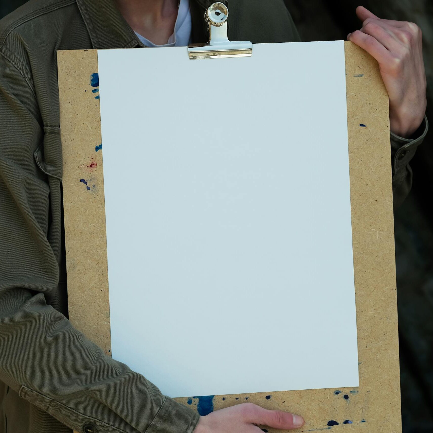 Close-up of a person holding a blank clipboard, ideal for design mockups and presentations.